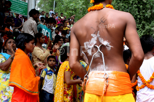 Hindu devotee gets his cheeks pierced