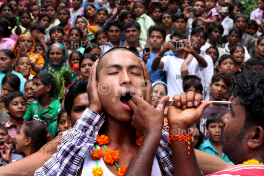 Hindu devotee gets his cheeks pierced