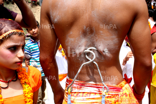 Hindu devotee gets his cheeks pierced