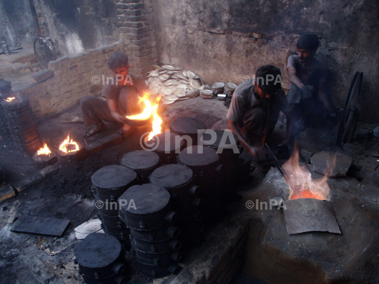 Labours melt metal to make plates