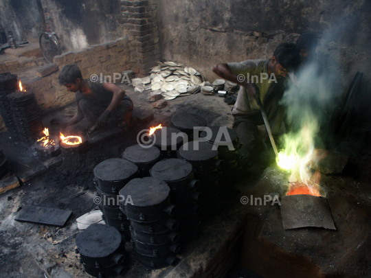 Labours melt metal to make plates